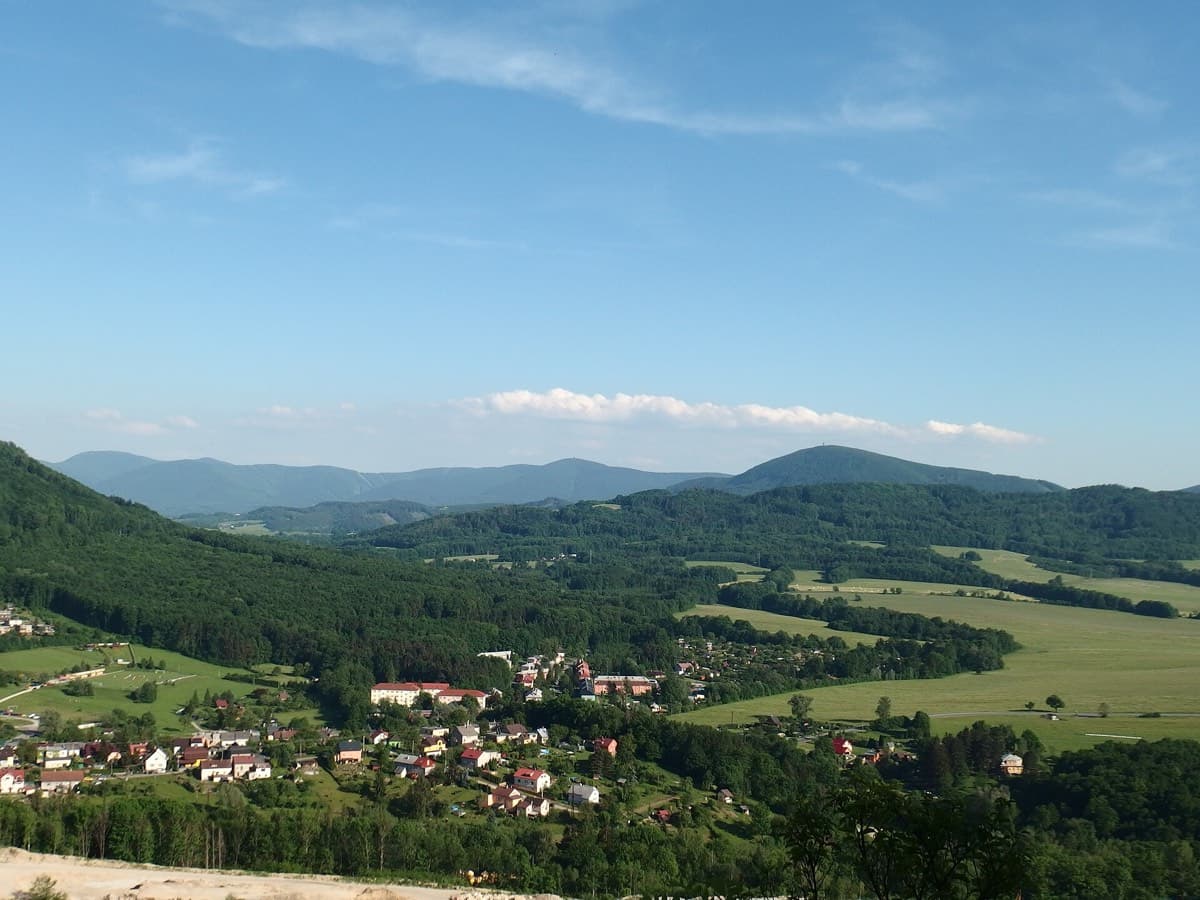 Zvlněné beskydské kopce s pastvinami a lesy
