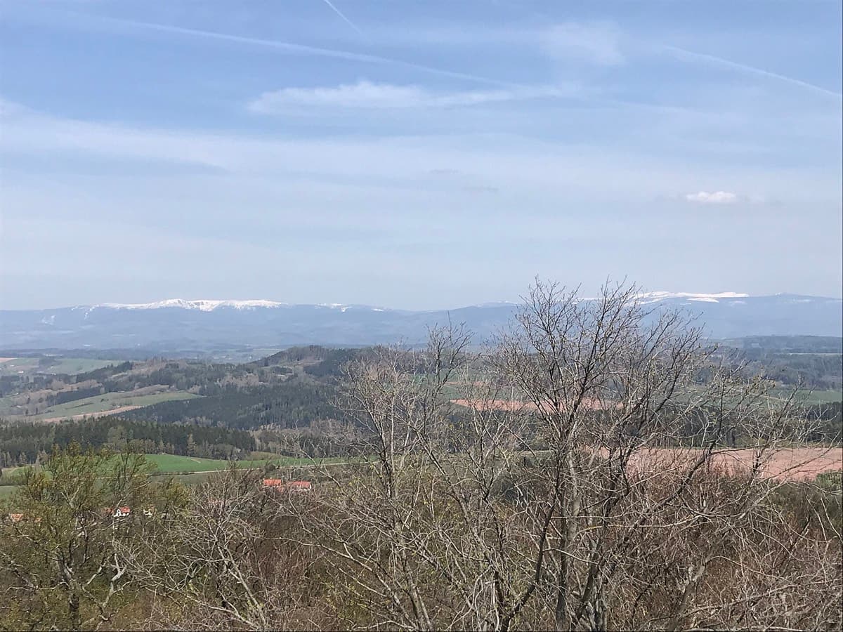 Pohled na krkonošské hřebeny nad zvlněnou krajinou