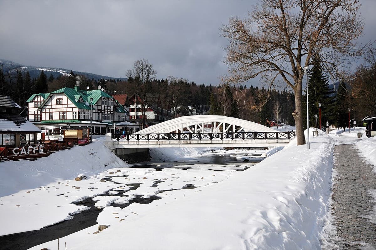 Penzion s dřevěnými prvky nad zamrzlou vodní hladinou